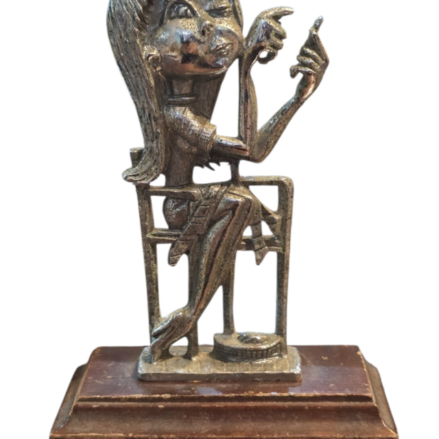 Antiga escultura em metal com base em madeira