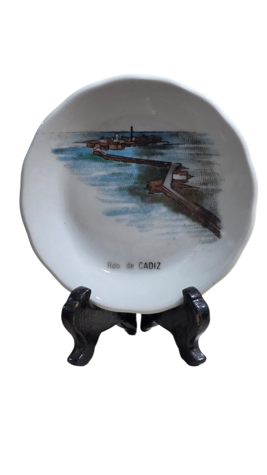Pequeno prato de porcelana souvenir com formato circular e borda ondulada