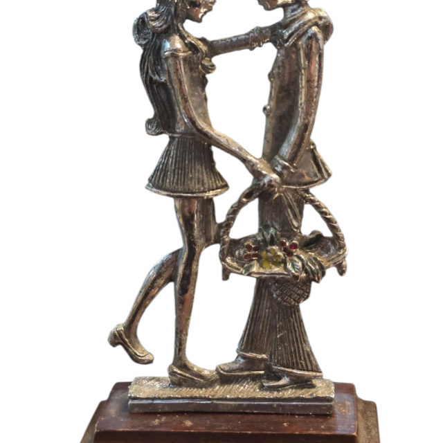 Antiga escultura em metal com base em madeira