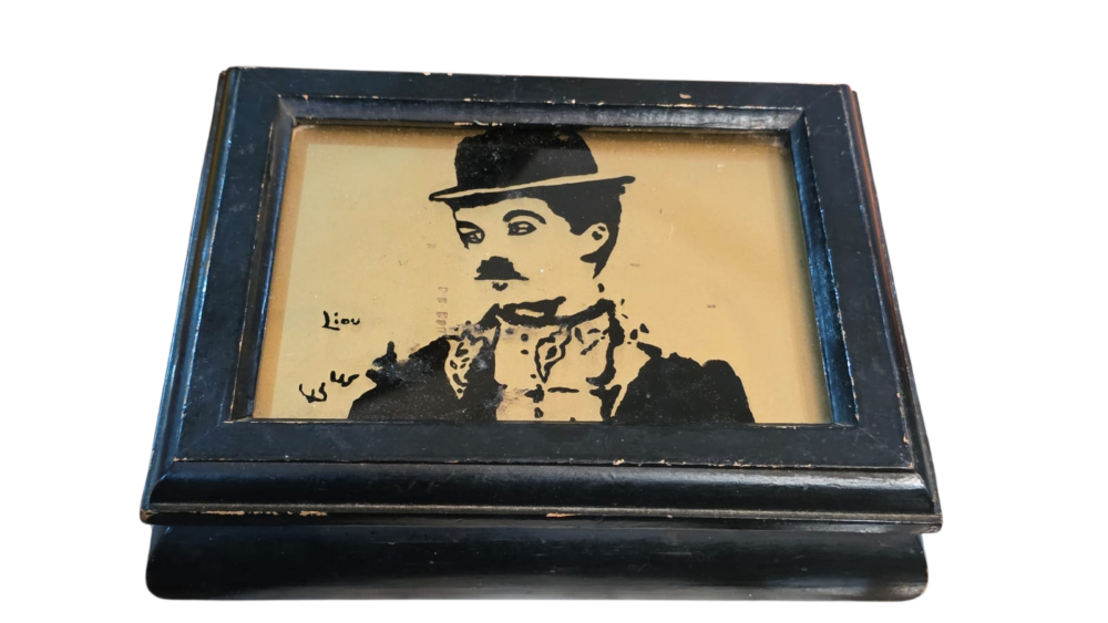 Caixa de madeira com imagem do Chaplin e vidro de proteção