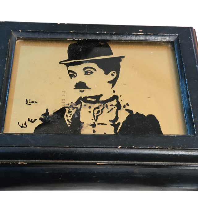 Caixa de madeira com imagem do Chaplin e vidro de proteção