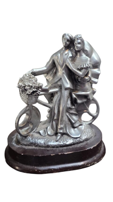 Escultura em resina representando elegante casal em sua bicicleta