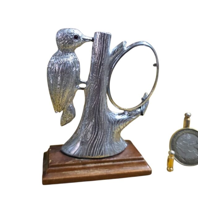 Escultura em metal com base de madeira representando um Pica-pau