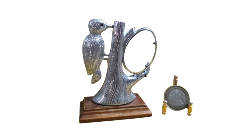 Escultura em metal com base de madeira representando um Pica-pau