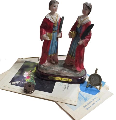 Imagem sacra de resina com diversos papéis antigos e carretel de linha
